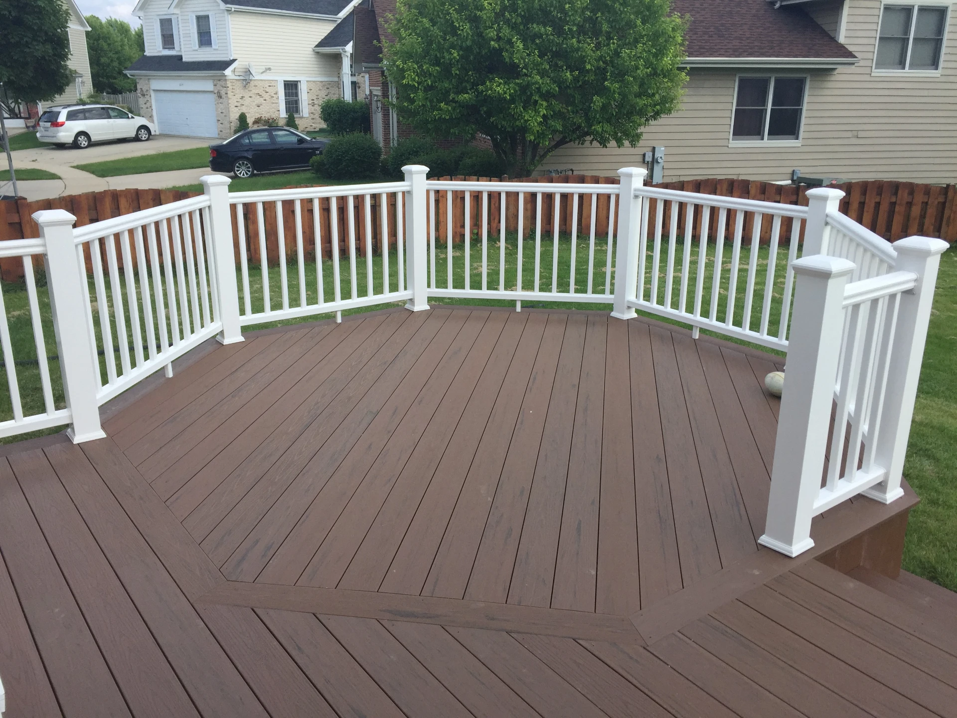 Octagonal capped composite deck with white railing and wooden small fence in schaumburg il