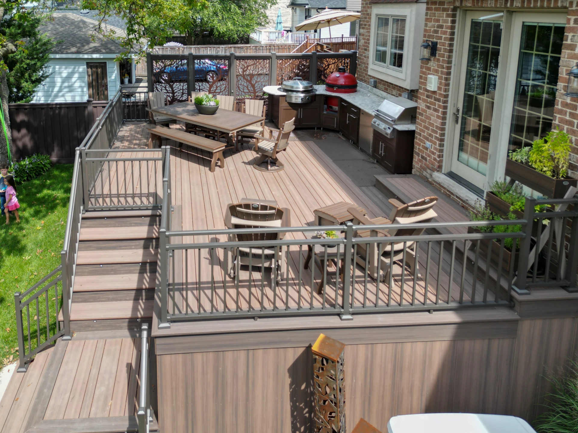 Voyage khaya and mesa deck with aluminum railings and custom powder coated aluminum privacy panels with outdoor kitchen